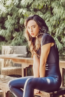 Amid Lush Foliage, Genevieve Liberte Poses Solo on Bench